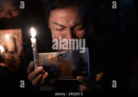 Eine Frau weint, als sie ein Bild des verstorbenen thailändischen Königs Bhumibol Adulyadej hält und während einer Gedenkfeier anlässlich seines Geburtstages am 5. Dezember 2016 in Sanam Luang in Bangkok, Thailand, eine Kerze anzündete. König Bhumibol, der längste regierende Monarch der Welt, starb am 13. Oktober 2016 im Alter von 88 Jahren im Siriraj-Krankenhaus. (Foto von Wasawat Lukharang/NurPhoto) *** Bitte nutzen Sie die Gutschrift aus dem Kreditfeld *** Stockfoto