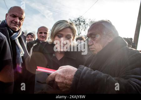 Marine Le Pen (M), die Vorsitzende der französischen rechtsextremen Front National (FN), Mitglied des Europäischen Parlaments und Kandidatin für die französischen Präsidentschaftswahlen 2017, erhielt am 8. Dezember ein Buch von Marcel Campion (R), dem Besitzer des Riesenrades auf dem concorde-Platz, während eines Besuchs auf einem Weihnachtsmarkt in Paris, 2016. (Foto von Michael Bunel/NurPhoto) *** Bitte nutzen Sie die Gutschrift aus dem Kreditfeld *** Stockfoto