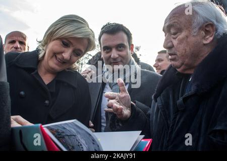 Marine Le Pen (M), die Vorsitzende der französischen rechtsextremen Front National (FN), Mitglied des Europäischen Parlaments und Kandidatin für die französischen Präsidentschaftswahlen 2017, erhielt am 8. Dezember ein Buch von Marcel Campion (R), dem Besitzer des Riesenrades auf dem concorde-Platz, während eines Besuchs auf einem Weihnachtsmarkt in Paris, 2016. (Foto von Michael Bunel/NurPhoto) *** Bitte nutzen Sie die Gutschrift aus dem Kreditfeld *** Stockfoto