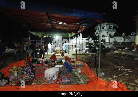 Die Bewohner schauen in Pidie Jaya, Aceh, am 9. Dezember 2016 nach dem Erdbeben der Stärke 6,5 auf der Richterskala in der Moschee Jami'Quba, die zerstört wurde. Das Beben zerstörte die großen Gebäude wie Moscheen, Einkaufszentren, Märkte und einige Häuser, wodurch die Bewohner an einen sicheren Ort umziehen konnten. Dasril Roszandi (Foto: Dasril Roszandi/NurPhoto) *** Bitte nutzen Sie die Gutschrift aus dem Kreditfeld *** Stockfoto