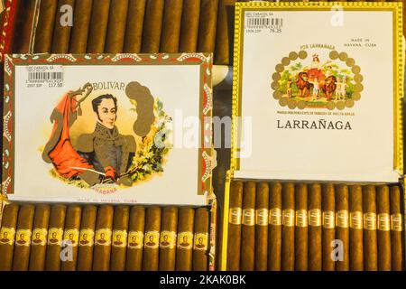 Kubanische Zigarren in einem Schaufenster. Diese Zigarren werden aus Tabakblättern gerollt, die im ganzen Land von Kuba gefunden werden. Der Füllstoff, das Bindemittel und die Verpackung können von verschiedenen Teilen der Insel kommen. Die gesamte Zigarrenproduktion in Kuba wird von der kubanischen Regierung kontrolliert, und jede Marke kann in verschiedenen Fabriken in Kuba gerollt werden. Kuba produziert sowohl handgefertigte als auch maschinengefertigte Zigarren. Alle Kartons und Etiketten sind mit Hecho en Cuba (Spanisch für Made in Cuba) gekennzeichnet. Von Hand fertig gefertigte maschinengefertigte Zigarren fügen Hecho ein Mano hinzu, während voll handgefertigte Zigarren Totalmente ein Mano im Drehbuch-Text sagen Stockfoto
