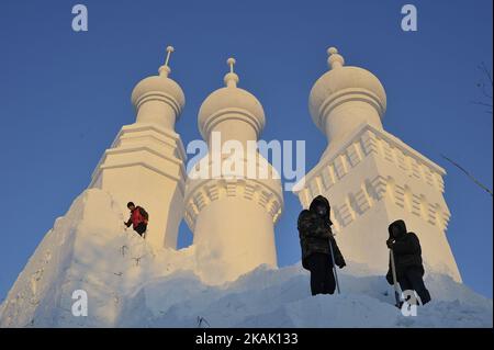 Chinesische Arbeiter schnitzen am 15. Dezember 2016 eine große Schneeskulptur für den Harbin Sun Island International Snow Sculpture Art Expo Park 29. in Harbin, der Hauptstadt der nordöstlichen Provinz Heilongjiang. Die größte Schneeskulptur, die 103 Meter lang und 31 Meter hoch ist, ist am Donnerstag im Park fertig gestellt. (Foto von Tao Zhang/NurPhoto) *** Bitte nutzen Sie die Gutschrift aus dem Kreditfeld *** Stockfoto