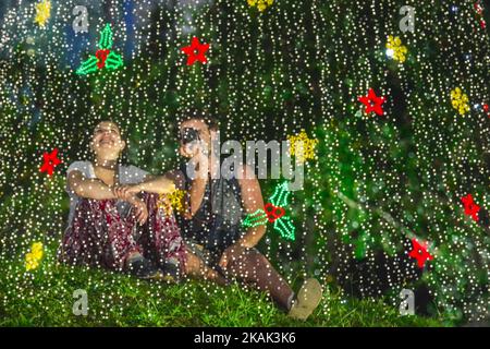 Ein Bild, das mit der Mehrfachbelichtungsfunktion der Kamera aufgenommen wurde, zeigt ein Paar, das am 23. Dezember 2016 Weihnachtsdekorationen vor KLCC, Kuala Lumpur fotografiert. Weihnachten ist das größte Fest der Christen, wird jedes Jahr am 25. Dezember gefeiert, um an die Geburt (bei der die Fakten, das Datum ist nicht das Datum seiner Geburt) Jesus Christus, auch bekannt als Jesus von Nazareth, der Gründer der christlichen Botschaft zu gedenken. Nach der Bibel, dem Neuen Testament, wurde Jesus der Jungfrau Maria in Jerusalem geboren. Christen glauben, dass JesusÃ¢Â € Â™ Geburt war innerhalb des Judentums Vorhersagen über die c Stockfoto