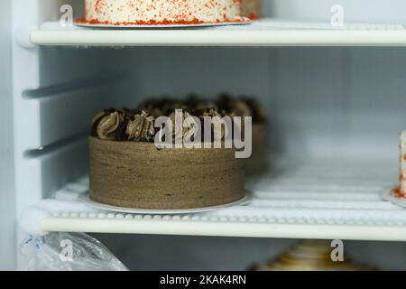 Cupcakes und Cupcakes auf einer Vitrine im Kühlschrank. Stockfoto