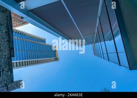 Blick von unten auf moderne Wolkenkratzer im Geschäftsviertel der Innenstadt von Austin Texas. Hoch aufragende Geschäftsgebäude mit Glasfensterfassade gegen Blau Stockfoto
