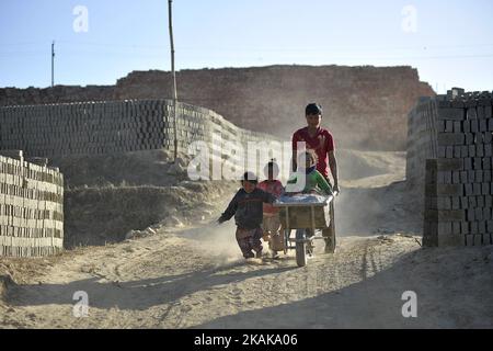 Ein Vater hilft seinen Kindern am Freitag, den 20. Januar 2017, auf dem Gelände rund um den Brick Klin in Patan, Nepal, auf Ziegeln zu spielen. (Foto von Narayan Maharjan/NurPhoto) *** Bitte nutzen Sie die Gutschrift aus dem Kreditfeld *** Stockfoto