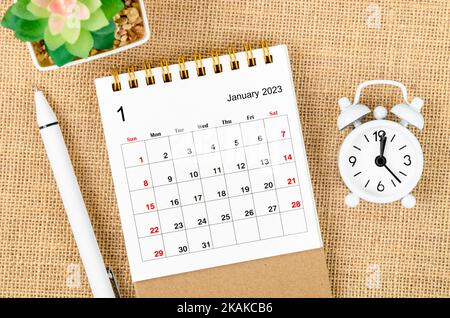 Januar 2023 Monatlicher Tischkalender für den Veranstalter zur Planung von 2023 Jahren mit Wecker und Stift auf Sackhintergrund. Stockfoto