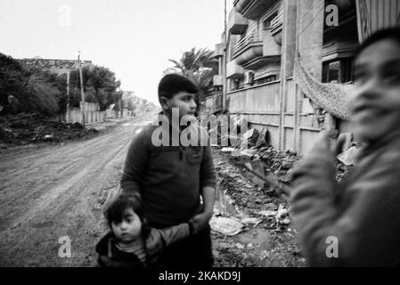 01/22/2017 Mosul, Irak. Bezirk Al Sukar genannt. Wie Zucker. Es sollte die Bitterkeit genannt werden, zumindest nach dem, was die Menschen in dieser Stadt erlebt haben. Die Straßen sind mit Muscheln übersät, überall in der Umgebung finden Sie verstreute Autowracks. Es ist schwer zu unterscheiden, welcher von ihnen für Selbstmordattentate verwendet werden soll. Einige Alleen durchziehen Leere, auf den anderen ziehen die Menschen ständig von Ort zu Ort. Die Leute wollen ihre Geschichten teilen - 'dort, neben der Lackiererei hat sich der Terrorist in die Luft gesprengt'. Seine Überreste liegen in einem Haufen Müll verstreut. Tatsächlich gab es zwei Stockfoto