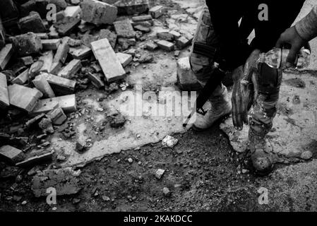 01/22/2017 Mosul, Irak. Bezirk Al Sukar genannt. Wie Zucker. Es sollte die Bitterkeit genannt werden, zumindest nach dem, was die Menschen in dieser Stadt erlebt haben. Die Straßen sind mit Muscheln übersät, überall in der Umgebung finden Sie verstreute Autowracks. Es ist schwer zu unterscheiden, welcher von ihnen für Selbstmordattentate verwendet werden soll. Einige Alleen durchziehen Leere, auf den anderen ziehen die Menschen ständig von Ort zu Ort. Die Leute wollen ihre Geschichten teilen - 'dort, neben der Lackiererei hat sich der Terrorist in die Luft gesprengt'. Seine Überreste liegen in einem Haufen Müll verstreut. Tatsächlich gab es zwei Stockfoto