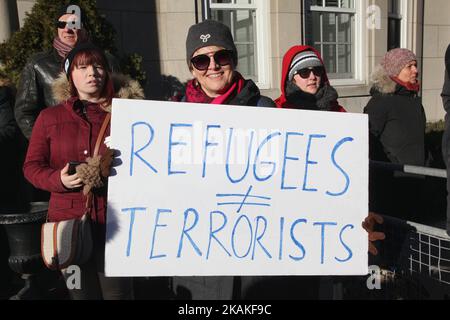 Frau hält während eines massiven Protests gegen das Reiseverbot von Präsident Trump vor dem US-Konsulat in der Innenstadt von Toronto, Ontario, Kanada, am 30. Januar 2017 ein Schild mit der Aufschrift „Flüchtlinge sind nicht gleich Terroristen“. Kanadier protestierten mit Ländern auf der ganzen Welt gegen die Exekutivordnung des amerikanischen Präsidenten Donald Trump, die Bürger von sieben mehrheitlich muslimischen Ländern (Iran, Irak, Sudan, Somalia, Syrien, Jemen und Libyen) die Einreise in die Vereinigten Staaten für die nächsten drei Monate und das Verbot syrischer Flüchtlinge, auf unbestimmte Zeit nach Amerika einzureisen. (Foto von Creative Touch Imaging Ltd./NurPho Stockfoto