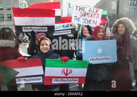 Muslimische Frauen halten während eines massiven Protests gegen das Reiseverbot von Präsident Trump vor dem US-Konsulat in der Innenstadt von Toronto, Ontario, Kanada, am 30. Januar 2017 Schilder mit den Flaggen der verbotenen Länder. Kanadier protestierten mit Ländern auf der ganzen Welt gegen die Exekutivordnung des amerikanischen Präsidenten Donald Trump, die Bürger von sieben mehrheitlich muslimischen Ländern (Iran, Irak, Sudan, Somalia, Syrien, Jemen und Libyen) die Einreise in die Vereinigten Staaten für die nächsten drei Monate und das Verbot syrischer Flüchtlinge, auf unbestimmte Zeit nach Amerika einzureisen. (Foto von Creative Touch Imaging Ltd./NurP Stockfoto