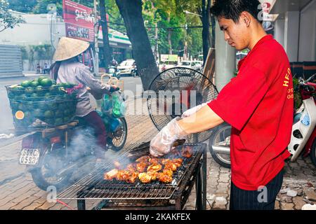 Vietnamesischer Mann kocht am Straßenrand Grill auf dem Straßenmarkt, Ho Chi Minh City, Vietnam Stockfoto