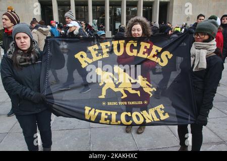 Frauen halten eine Flagge mit der Aufschrift „Flüchtlinge willkommen“, während Tausende Kanadier am 04. Februar 2017 am Nationalen Aktionstag gegen Islamophobie und Weiße Suprematie in der Innenstadt von Toronto, Ontario, Kanada, an einem massiven Protest gegen das Reiseverbot von Präsident Trump gegen Muslime teilnehmen. Kanadier protestierten mit Ländern auf der ganzen Welt gegen die Exekutivordnung des amerikanischen Präsidenten Donald Trump, die Bürger von sieben mehrheitlich muslimischen Ländern (Iran, Irak, Sudan, Somalia, Syrien, Jemen und Libyen) die Einreise in die Vereinigten Staaten für die nächsten drei Monate und das Verbot syrischer Flüchtlinge aus ind Stockfoto