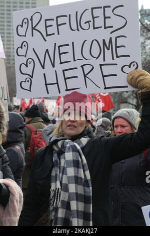 Frau hält ein Schild mit der Aufschrift „Flüchtlinge willkommen hier“, während Tausende von Kanadiern am National Day of Action Against Islamophobia and White Supremacy in Downtown Toronto, Ontario, Kanada, am 04. Februar 2017 an einem massiven Protest gegen das Reiseverbot von Präsident Trump für Muslime teilnehmen. Kanadier protestierten mit Ländern auf der ganzen Welt gegen die Exekutivordnung des amerikanischen Präsidenten Donald Trump, die Bürger von sieben mehrheitlich muslimischen Ländern (Iran, Irak, Sudan, Somalia, Syrien, Jemen und Libyen) die Einreise in die Vereinigten Staaten für die nächsten drei Monate und das Verbot syrischer Flüchtlinge Fr. Stockfoto