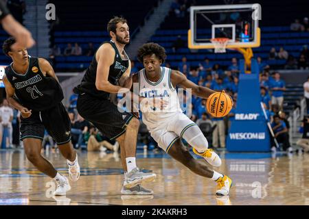 UCLA Bruins Wache David Singleton (34) fährt gegen Concordia Golden Eagles Vorwärts Cameron Fini (5) während eines NCAA Männer Ausstellung Basketballspiel, Stockfoto