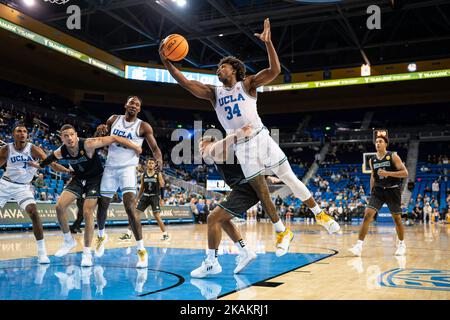 Der UCLA Bruins-Wächter David Singleton (34) bekommt einen Rebound und wird während einer NCAA-Männerausstellung b von der Concordia Golden Eagles-Garde Kobe Sanders (1) angestachelt Stockfoto