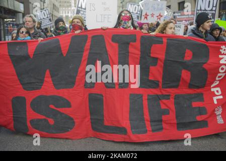 Demonstranten marschierten am 4. März 2017 mit einer Polizeieskorte in Manhattan auf die fünfte Straße. Eine Veranstaltung auf facebook, die als Zeichen der Solidarität mit den Wasserschutzern in Standing Rock, Cannonball, North Dakota, entstand, wurde viral und verursachte etwa 1000 Menschen, die Straßen in Manhattan zu besuchen und zum Columbus Cirlce zu marschieren, vorbei am Trump Tower und den Trump Hotels. (Foto von Shay Horse/NurPhoto) *** Bitte nutzen Sie die Gutschrift aus dem Kreditfeld *** Stockfoto