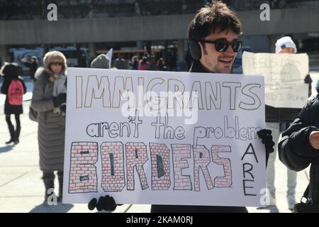 Pro-muslimischer Protestler, der ein Schild trägt, das sagt: „Einwanderer sind nicht das Problem, Grenzen sind es!“ Während der pro-muslimischen und anti-muslimischen Demonstrationen in der Innenstadt von Toronto, Ontario, Kanada, am 04. März 2017, prallten oppositionellen Gruppen von Demonstranten über den M-103-Antrag zur Bekämpfung von Islamophobie zusammen. Kanadier im ganzen Land veranstalteten ähnliche Proteste gegen den Islam; Muslime; Scharia-Gesetz und M-103. Auf diese Proteste stießen Gegenproteste von Unterstützenden und Befürwortern von M-103. M-103 ist ein Antrag von Privatmitgliedern, der vom liberalen Abgeordneten Iqra Khalid gestellt wurde und die Regierung auffordert, die Notwendigkeit von qu zu erkennen Stockfoto