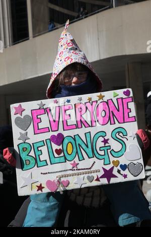 Mädchen mit einem Schild mit der Aufschrift „jeder gehört“, als sich am 04. März 2017 während Pro-muslimischer und Anti-Muslims-Demonstrationen in der Innenstadt von Toronto, Ontario, Kanada, gegnerische Gruppen von Demonstranten über den M-103-Antrag zur Bekämpfung von Islamophobie zusammenschlugen. Kanadier im ganzen Land veranstalteten ähnliche Proteste gegen den Islam, Muslime, das Scharia-Gesetz und M-103. Auf diese Proteste stießen Gegenproteste von Unterstützenden und Befürwortern von M-103. M-103 ist ein privater Antrag der liberalen Abgeordneten Iqra Khalid, der die Regierung auffordert, die Notwendigkeit zu erkennen, das zunehmende öffentliche Klima des Hasses und zu unterdrücken Stockfoto