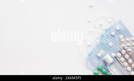 Draufsicht auf Packung blauer Schutzmasken, durchsichtiger Flasche Desinfektionsgel und verschiedenen Streutabletten. Coronavirus COVID-19-Konzept auf Stockfoto