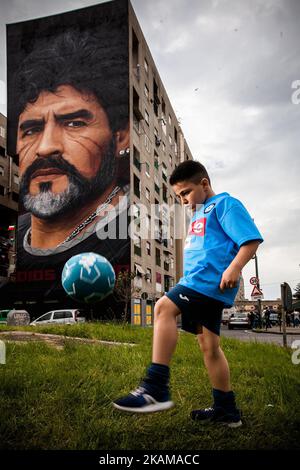 Ein Kind, das von Taverna Del Ferro, San Giovanni a Teducchio, Peripherie von Neapel EST am 29. März 2017 vor einem Graffiti Revolucionario von Jorit, handbemalt an der Wand mit Sprühdosen, Diego Armando Maradona an der Wand eines Gebäudes tröpfelt. (Foto von Paolo Manzo/NurPhoto) *** Bitte nutzen Sie die Gutschrift aus dem Kreditfeld *** Stockfoto