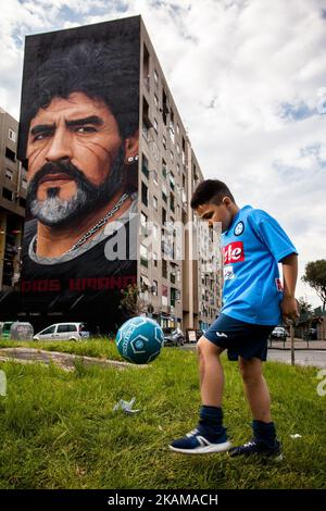 Ein Kind, das von Taverna Del Ferro, San Giovanni a Teducchio, Peripherie von Neapel EST am 29. März 2017 vor einem Graffiti Revolucionario von Jorit, handbemalt an der Wand mit Sprühdosen, Diego Armando Maradona an der Wand eines Gebäudes tröpfelt. (Foto von Paolo Manzo/NurPhoto) *** Bitte nutzen Sie die Gutschrift aus dem Kreditfeld *** Stockfoto