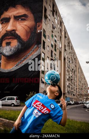 Ein Kind, das von Taverna Del Ferro, San Giovanni a Teducchio, Peripherie von Neapel EST am 29. März 2017 vor einem Graffiti Revolucionario von Jorit, handbemalt an der Wand mit Sprühdosen, Diego Armando Maradona an der Wand eines Gebäudes tröpfelt. (Foto von Paolo Manzo/NurPhoto) *** Bitte nutzen Sie die Gutschrift aus dem Kreditfeld *** Stockfoto