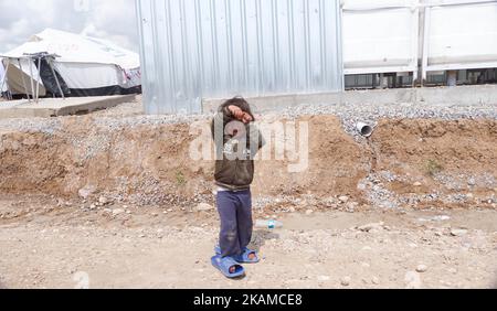 Kinder posieren im Lager Chamakor, östlich von Mosul, Irak, wo sich eine große Anzahl von Menschen niedergelassen hat, nachdem sie am 5. April 2017 im irakischen Hamam al-Alil, während der Offensive der irakischen Armee zur Rückeroberung der Stadt Mosul, vertrieben worden waren. Binnenvertriebene (IDP) waren im Lager Chamakor östlich von Mosul zu sehen, während der Kampf gegen den Islamischen Staat andauert. Seit der Eröffnung vor 3 Wochen leben mehr als 11 000 IDP im Lager. Das Lager ist so groß, dass die UNO eine neue Einrichtung für andere IDPs aus dem Westen von Mosul errichtet. Trockene Lebensmittelpakete werden verteilt, während die Menschen warten Stockfoto