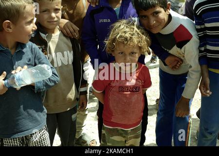 Kinder posieren im Lager Chamakor, östlich von Mosul, Irak, wo sich eine große Anzahl von Menschen niedergelassen hat, nachdem sie am 5. April 2017 im irakischen Hamam al-Alil, während der Offensive der irakischen Armee zur Rückeroberung der Stadt Mosul, vertrieben worden waren. Binnenvertriebene (IDP) waren im Lager Chamakor östlich von Mosul zu sehen, während der Kampf gegen den Islamischen Staat andauert. Seit der Eröffnung vor 3 Wochen leben mehr als 11 000 IDP im Lager. Das Lager ist so groß, dass die UNO eine neue Einrichtung für andere IDPs aus dem Westen von Mosul errichtet. Trockene Lebensmittelpakete werden verteilt, während die Menschen warten Stockfoto