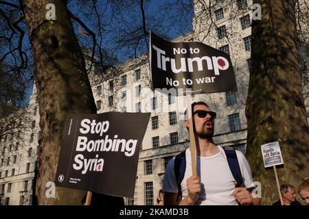 Demonstranten halten Plakate während eines Protestes gegen die Entscheidung des US-Präsidenten Donald Trump, Angriffe auf syrische Ziele zu starten, die von der Stop the war Coalition in Whitehall gegenüber der Downing Street in London am 7. April 2017 organisiert wurde. DIE US-Streitkräfte feuerten am Freitag als Reaktion auf einen vermuteten chemischen Angriff eine Flut von Marschflugkörpern auf einen syrischen Luftwaffenstützpunkt und verurteilten das Regime von Damaskus und seinen wichtigsten Verbündeten Russland wütend. (Foto von Jay Shaw Baker/NurPhoto) *** Bitte nutzen Sie die Gutschrift aus dem Kreditfeld *** Stockfoto