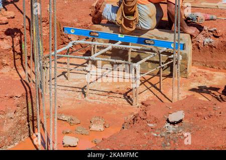 Stahlstäbe werden auf der Baustelle in Gräben gesteckt, um Betonfundamente mit Stahlstäben zu verstärken Stockfoto