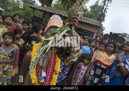 Ein Anhänger hält am 13. April 2017 in Burdwan, Indien, einen menschlichen Kopf in der Hand. 'Gajan' ist eines der prominenten Volksfeste Bengalens, das meistens von den geplanten Kastenmenschen an den letzten zwei Tagen des Monats Chaitra gefeiert wird. Diese Periode wird als chaita sankranti bekannt, wenn die Sonne in das Fische-Zeichen eintritt. Das Festival findet auf freiem Gelände statt und nicht in irgendjemandem. Menschen, die an diesem Fest beteiligt sind, werden von der Masse als die Vertreter von Herrn Shiva respektiert. Die Menschen glauben, dass das Festival ihnen Wohlstand beschert und alle Sorgen beseitigt, die sie in der erlitten haben Stockfoto