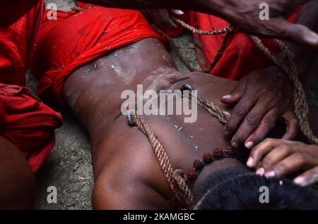 Indischer hinduistischer Anhänger, der am Freitag, den 14.. April 2017, während des Gajan-Festivals im Bezirk Burdwan in Westbengalen, Indien, mit Eisenhaken durchbohrt wurde.Gajan ist ein Hindu-Fest, das hauptsächlich im indischen Bundesstaat Westbengalen gefeiert wird. Es ist mit Gottheiten wie Shiva, Neel und Dharmathakur verbunden. Gajan erstreckt sich über eine Woche, beginnend mit der letzten Woche von Chaitro, die bis zum Ende des bengalischen Jahres andauert. Es endet mit Charak Puja. Die Teilnehmer dieses Festivals sind als Sannyasi oder Bhokta bekannt. Das zentrale Thema dieses Festivals ist die Befriedigung durch Hingabe und Opfer. (Foto von Sonali Pal Stockfoto