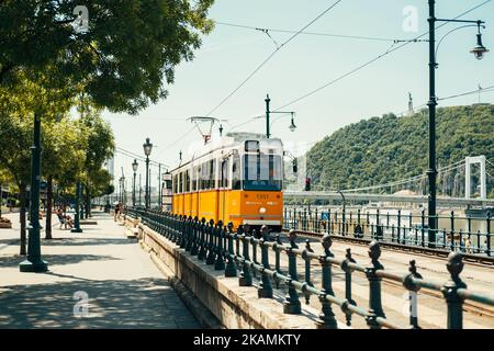 Ungarn, Budapest. 15. JUNI 2022. Gelbe Straßenbahn am Donauufer in Budapest an einem schönen Sommersonntag. Stockfoto