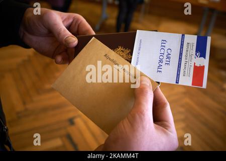 Ein Mann zeigt seinen Pass, seinen Wählerausweis und seinen Stimmzettel, um seine Stimme im Wahllokal von Capitole für die erste Runde der französischen Präsidentschaftswahlen im April 23. 2017 in Toulouse, Frankreich, abzugeben. Die ersten Präsidentschaftswahlen in Frankreich, gefolgt von der zweiten Runde am 7. Mai, die von den beiden besten Kandidaten bestritten wird. Zu diesen gehören der Mitte-Rechts-Francois Fillon (Les Republicains), die rechtsextreme Marine Le Pen (Front National), Benoit Hamon (Sozialisten), der unabhängige Zentrist Emmanuel Macron (en Marche!) und der linke Jean-Luc Melenchon (La France Insoumise). (Foto von Alain Stockfoto