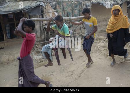 Mohammad Shafi, 55, der während der jüngsten Gewalt infolge der Verfolgung durch Muslime in Myanmar sein Bein verlor, wird am 6. März 2017 wegen fehlender Transportmöglichkeiten im Flüchtlingslager Kutupalong, Cox's Bazar, Bangladesch, mit Bambus in das Krankenhaus gebracht. Die birmanische Armee schoss ihn in sein Bein, während er in einem Reisfeld arbeitete. Seit dem 9. Oktober 2016 sind rund 70.000 Rohingya-Muslime aus Myanmar nach Bangladesch geflohen, nachdem das birmanische Militär Räumungsoperationen gestartet hat. Das UN-Menschenrechtsbüro sagte in ihrem Bericht, dass die Sicherheitskräfte Myanmars Massenmorde und Folter begangen haben Stockfoto