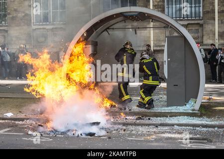 Französische Feuerwehrleute schützen ihr Gesicht, wenn sie sich einem Feuer auf einer station in autolib nähern, nachdem Demonstranten und französische Anti-Aufrührer während eines marsches zur jährlichen Arbeiterversammlung am 1. Mai 2017 in Paris zusammengekommen waren. Die gewalttätigen Unruhen vom ersten Mai 2017, die 6 Polizisten verletzt haben, können molotow-Koktail und 5 Demonstranten verärgerten. (Foto von Julien Mattia/NurPhoto) *** Bitte nutzen Sie die Gutschrift aus dem Kreditfeld *** Stockfoto