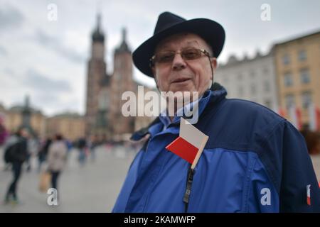 Am Tag der polnischen Flagge trägt ein Mann eine kleine weiße und rote Fahne an seiner Jacke. Der Flaggentag wurde 2004 in Polen eingeführt und überbrückt die Lücke zwischen dem Internationalen Arbeitertag am 1.. Mai und dem Tag der Verfassung am 3.. Mai. Heute wurden im ganzen Land Hunderte von verschiedenen Veranstaltungen organisiert, eine davon, die „White and Red Relay RMF FM“. Um 6 Uhr verließ die Staffel mit der polnischen Flagge Hel, im Norden Polens, mit der Flagge, die mit dem Boot in Sopot eintraf, und dann von Danzig nach Warschau mit dem Flugzeug. In der Hauptstadt, der Hauptpunkt des Programms, war ein Relais von Politikern. Eine weitere Station war Krakau Stockfoto