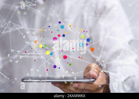 Eine 3D Rendering einer bunten Kommunikations-Blockchain, die über einem Tablet schwebt Stockfoto