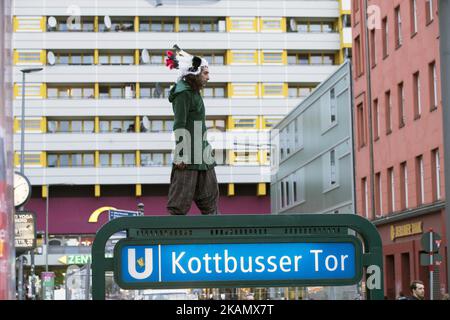 Ein Mann mit indischen Federn geht am 3. Mai 2017 auf das ausgeschilderte Schild der U-Bahnstation Kottbusser Tor im Berliner Bezirk Kreuzberg. (Foto von Emmanuele Contini/NurPhoto) *** Bitte benutzen Sie die Gutschrift aus dem Kreditfeld *** Stockfoto