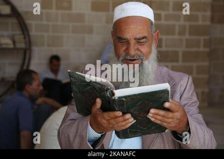 Ein Palästinenser liest am ersten Fastentag im muslimischen Monat Ramadan in der al-Omari-Moschee in Gaza-Stadt am 27. Mai 2017 eine Kopie des Korans, des heiligsten Buches des Islam. Mehr als 1,5 Milliarden Muslime auf der ganzen Welt werden den Monat markieren, in dem Gläubige von Sonnenaufgang bis Sonnenuntergang auf Essen, Trinken und Rauchen verzichten. (Foto von Majdi Fathi/NurPhoto) *** Bitte nutzen Sie die Gutschrift aus dem Kreditfeld *** Stockfoto