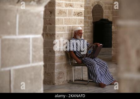 Ein Palästinenser liest am ersten Fastentag im muslimischen Monat Ramadan in der al-Omari-Moschee in Gaza-Stadt am 27. Mai 2017 eine Kopie des Korans, des heiligsten Buches des Islam. Mehr als 1,5 Milliarden Muslime auf der ganzen Welt werden den Monat markieren, in dem Gläubige von Sonnenaufgang bis Sonnenuntergang auf Essen, Trinken und Rauchen verzichten. (Foto von Majdi Fathi/NurPhoto) *** Bitte nutzen Sie die Gutschrift aus dem Kreditfeld *** Stockfoto