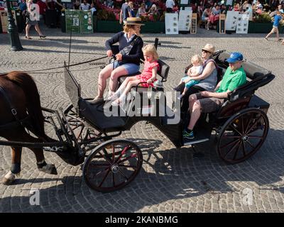 Ein lokaler Reisebus fährt am 24. Mai 2017 eine Pferdekutsche durch eine historische Straße in Brügge, Belgien. An einem der wärmsten Tage des Jahres wurde Brügge von Tausenden von Touristen aus der ganzen Welt ausgewählt. Dies ist die Hauptstadt und größte Stadt der Provinz Westflandern in der flämischen Region Belgiens, im Nordwesten des Landes. Da Brügge ein riesiges Touristenziel ist, haben Touristen eine große Auswahl, um die Stadt zu genießen, wie Pferdekutschenfahrten, Grachtenfahrten mit dem Boot oder einfach nur einen Spaziergang durch das historische Stadtzentrum. (Foto von Romy Arroyo Fernande Stockfoto