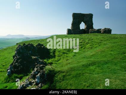 Sehen Sie nordwestlich von Dunnideer Iron Age Vitrified Fort, Aberdeenshire, Schottland, Großbritannien, mit Steinklumpen, die durch intensive Hitze verschmolzen wurden, und der mittelalterlichen Burg. Stockfoto