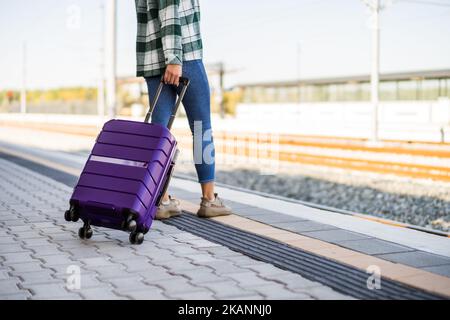 Frau mit Koffer auf dem Bahnhof. Stockfoto
