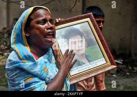 Maksuda Begum weint, als sie ein Foto ihres Sohnes Jakir Hossain Shaon hält, der beim Angriff auf den ehemaligen Standort der Bäckerei Holey Artisan am 1. Juli 2017 in Dhaka, Bangladesch, getötet wurde. Am 1. Juli 2016 tötete ein brutaler Angriff des Islamischen Staates 18 Ausländer und vier Bangladeschis in der Bäckerei Holey Artisan. Dann hielten sie Personal und Mäzene 10 Stunden lang als Geisel. (Foto von Sony Ramany/NurPhoto) *** Bitte nutzen Sie die Gutschrift aus dem Kreditfeld *** Stockfoto