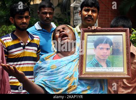 Maksuda Begum weint, als sie ein Foto ihres Sohnes Jakir Hossain Shaon hält, der beim Angriff auf den ehemaligen Standort der Bäckerei Holey Artisan am 1. Juli 2017 in Dhaka, Bangladesch, getötet wurde. Am 1. Juli 2016 tötete ein brutaler Angriff des Islamischen Staates 18 Ausländer und vier Bangladeschis in der Bäckerei Holey Artisan. Dann hielten sie Personal und Mäzene 10 Stunden lang als Geisel. (Foto von Sony Ramany/NurPhoto) *** Bitte nutzen Sie die Gutschrift aus dem Kreditfeld *** Stockfoto