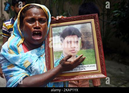 Maksuda Begum weint, als sie ein Foto ihres Sohnes Jakir Hossain Shaon hält, der beim Angriff auf den ehemaligen Standort der Bäckerei Holey Artisan am 1. Juli 2017 in Dhaka, Bangladesch, getötet wurde. Am 1. Juli 2016 tötete ein brutaler Angriff des Islamischen Staates 18 Ausländer und vier Bangladeschis in der Bäckerei Holey Artisan. Dann hielten sie Personal und Mäzene 10 Stunden lang als Geisel. (Foto von Sony Ramany/NurPhoto) *** Bitte nutzen Sie die Gutschrift aus dem Kreditfeld *** Stockfoto