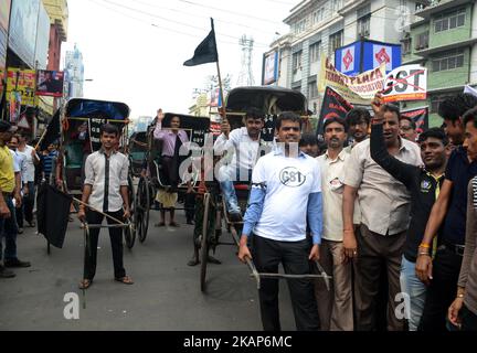 Tuchhändler und -Arbeiter rufen Slogans und ziehen die Rickshaw in Burrabazar während des Streiks gegen GST in Kalkutta, Indien, am Mittwoch, 12.. Juli 2017.Tuchhändler gehen Anfang Juni 27 landesweit streiken, um gegen 5 Prozent der GST (Waren- und Dienstleistungssteuer) zu protestieren, die auf die Dienstleistungen erhoben wurden (Arbeit) von ihnen für die Textilindustrie geleistet. Textilhändler protestieren im ganzen Land gegen ‘komplexe, verwirrende’ GST-Regeln (Waren- und Dienstleistungssteuer). (Foto von Sonali Pal Chaudhury/NurPhoto) *** Bitte nutzen Sie die Gutschrift aus dem Kreditfeld *** Stockfoto