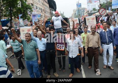 Tuchhändler und -Arbeiter rufen Slogans und ziehen die Rickshaw in Burrabazar während des Streiks gegen GST in Kalkutta, Indien, am Mittwoch, 12.. Juli 2017.Tuchhändler gehen Anfang Juni 27 landesweit streiken, um gegen 5 Prozent der GST (Waren- und Dienstleistungssteuer) zu protestieren, die auf die Dienstleistungen erhoben wurden (Arbeit) von ihnen für die Textilindustrie geleistet. Textilhändler protestieren im ganzen Land gegen ‘komplexe, verwirrende’ GST-Regeln (Waren- und Dienstleistungssteuer). (Foto von Sonali Pal Chaudhury/NurPhoto) *** Bitte nutzen Sie die Gutschrift aus dem Kreditfeld *** Stockfoto